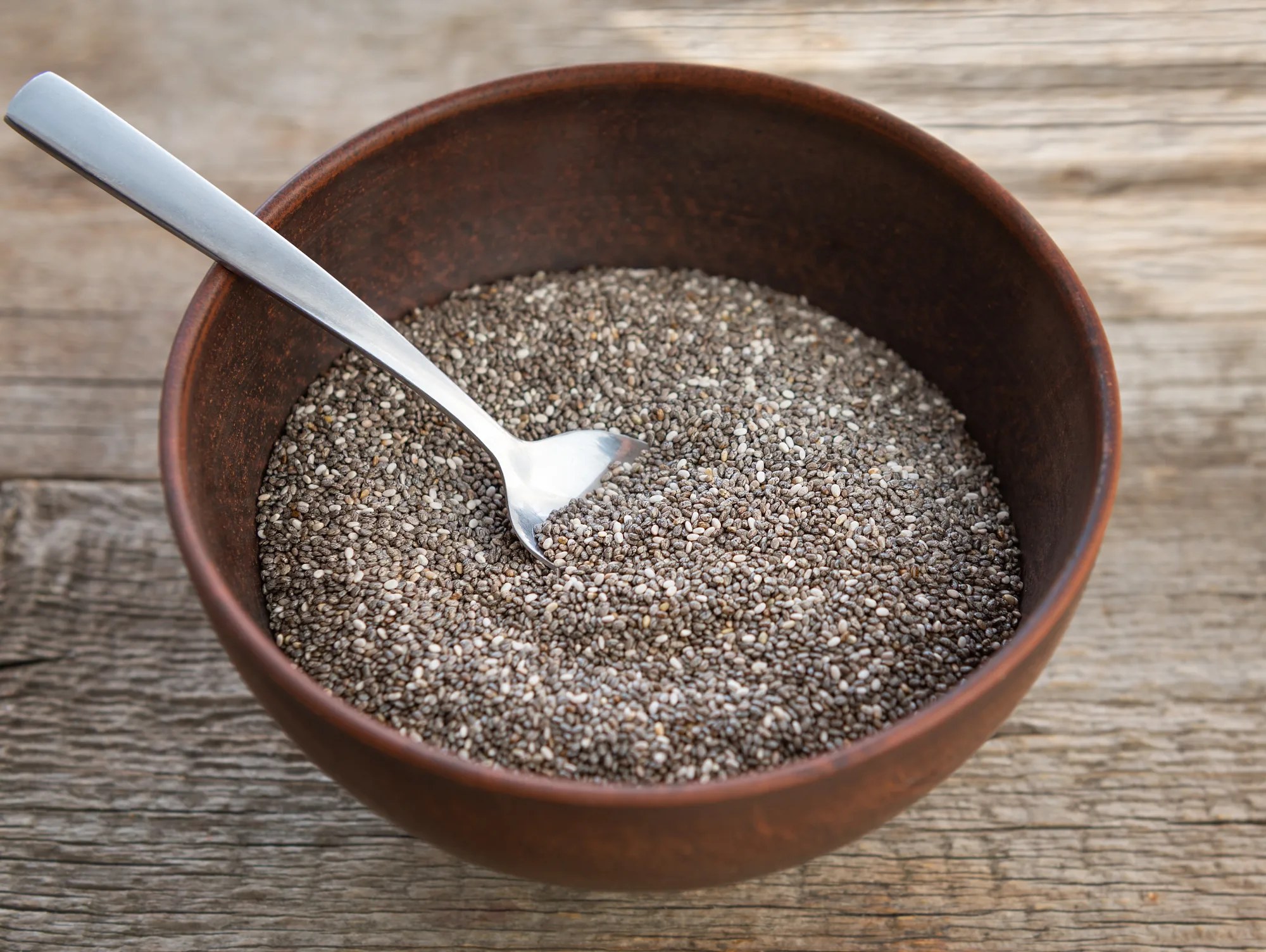 a bowl of chia seeds with a spoon